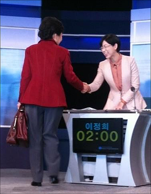 2개 가방을 들고 있는 박근혜 후보가 이정희 후보와 토론장 안에서 악수를 하고 있다. ⓒ 통합진보당 이상규 의원 트위터(@whitefireg)
