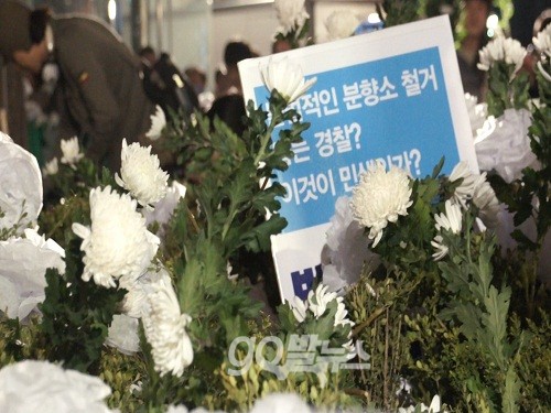 시민들이 꽃을 화단에 던지자 경찰은 시민들이 “화단의 펜스를 무너뜨리고 있다”며 “사법처리 하겠다”고 엄포를 놨다. ⓒ 'go발뉴스'