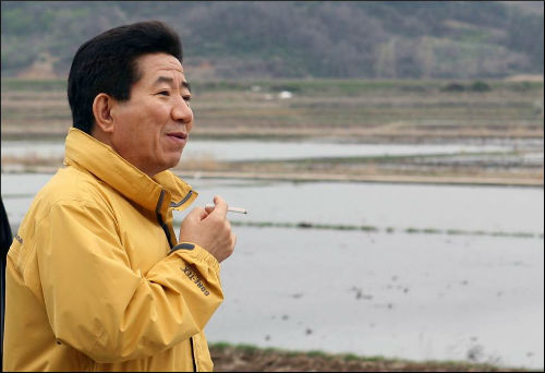 경남 김해 봉하마을에서 모내기를 위해 물 댄 논을 바라보고 있는 모습(2006년) ⓒ노무현재단