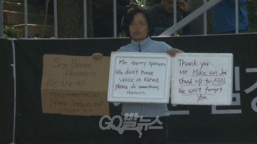 신도로 추정되는 한 외국인 여성이 도움을 호소하는 피켓을 들고 있다 ⓒ'go발뉴스'