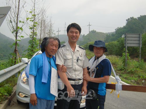 세월호 십자가 순례단의 안전한 순례를 위해 경찰들의 에스코트가 이날도 이어졌다. 천안동남경찰서의 최상 순경(가운데)이 이호진, 김학일씨와 기념사진을 찍고 있다.