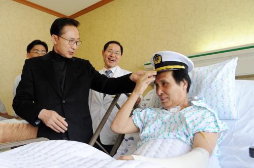 이명박 전 대통령이 2011년 3월 삼호주얼리호 구출과정에서 총상을 입은 석해균 선장을 위로방문해 선장모자와 예복을 선물했다. © 문화체육관광부 한국정책방송원