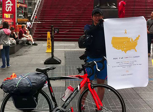 류승우씨가 자전거 횡단을 시작한 지난해 6월 8일 뉴욕 맨해튼 타임스퀘어에서 세월호 플랜카드를 들고 있다.©Pray for South korea