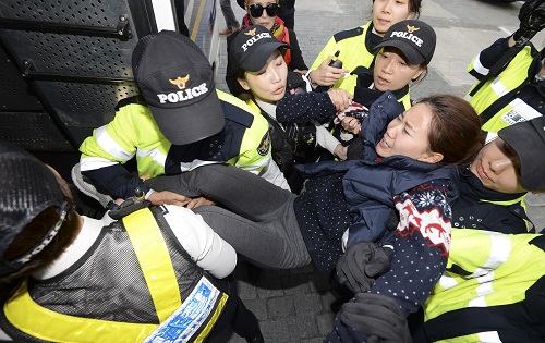 경찰이 12일 오후 서울 광화문 광장 이순신장군 동상 앞에서 정부의 역사 교과서 국정화에 반대하는 기습시위를 벌인 학생을 연행하고 있다. <사진제공=뉴시스>