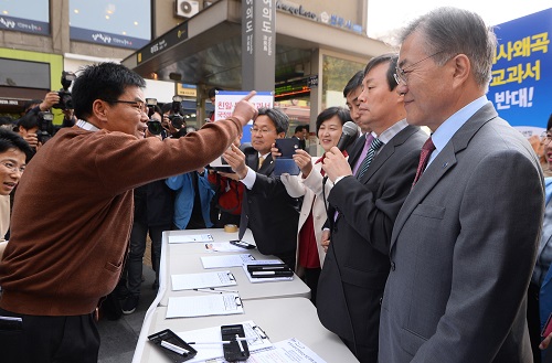 새정치민주연합 문재인 대표 등 지도부가 13일 서울 영등포구 여의도역 입구에서 국정교과서 반대 대국민 서명운동을 펼치자 보수단체 회원들이 난입해 항의하고 있다. <사진제공=뉴시스>