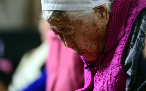 한·일 외교장관 회담에서 위안부 문제해결이 타결된 28일 오후 경기도 광주시 퇴촌면 나눔의 집에서 일본군 '위안부' 피해자 이옥선 할머니가 한일 외교장관의 공식 기자회견을 시청하며 고개를 숙이고 있다. <사진제공=뉴시스>