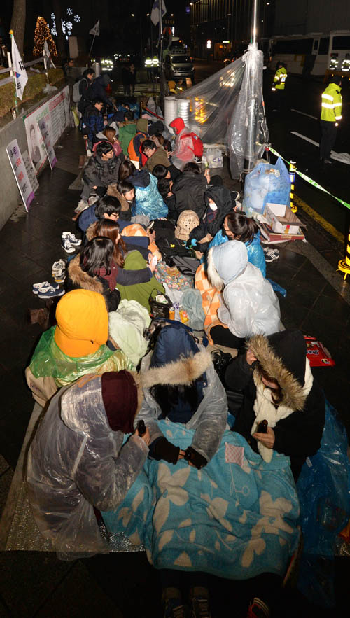 2015년 마지막 수요시위가 열린 30일 저녁 서울 종로구 중학동 일본대사관 앞 소녀상 곁에서 열린 '일본군 위안부 문제 한·일 협상안 폐기'를 촉구하는 촛불문화제를 끝낸 대학생들이 밤샘 연좌농성을 하고 있다.<사진제공=뉴시스>