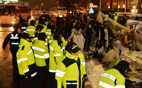 2015년 마지막 수요시위가 열린 30일 저녁 서울 종로구 중학동 일본대사관 앞 소녀상 곁에서 열린 '일본군 위안부 문제 한·일 협상안 폐기'를 촉구하는 촛불문화제이 끝나자 밤샘 연좌농성을 시작하려는 참가자들을 경찰이 둘러싸고 있다. <사진제공=뉴시스>