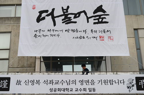 17일 오후 서울 구로구 성공회대학교 대학성당에 차려진 故 신영복 성공회대 석좌교수의 빈소를 찾은 한 시민이 추모객들이 적어놓은 엽서를 읽어보고 있다.영결식은 18일 11시에 대학성당에서 거행되며, 고 신영복 교수는 지난 2014년 희귀 피부암 진단을 받고 투병 중, 지난 15일 끝내 별세했다. 향년 75세. <사진제공=뉴시스>