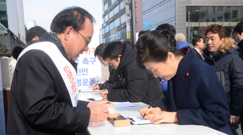 박근혜 대통령이 18일 오후 경기도 성남시 판교역 광장에서 열린 민생구하기 입법 촉구 천만 서명운동 행사장을 찾아 서명하고 있다. <사진제공=뉴시스>