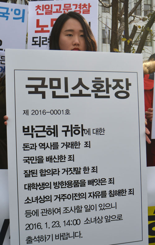 미신고 불법집회 열어 한일 위안부협상 폐기를 주장하고 소녀상 지키기 노숙농성을 벌인 이유로 출석요구서를 받은 한일 일본군위안부 합의 무효를 위한 대학생 대책위 회원들이 21일 오후 서울 종로구 종로경찰서 앞에서 박근혜 대통령을 규탄하는 문구가 적힌 피켓을 들고 있다. <사진제공=뉴시스>