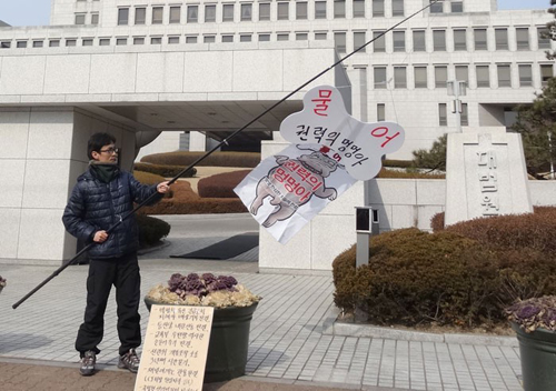 ‘둥글이’ 박성수씨가 지난 4일 대법원 앞에서 사법부를 비판하는 ‘물어 권력의 멍멍아’ 퍼포먼스를 하고 있다. <사진출처=페이스북>