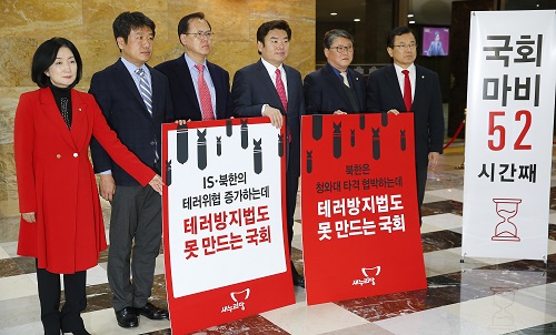 테러방지법 처리 저지를 위해 야당의원들이 52시간동안 무제한 토론을 이어가고 있는 25일 밤 국회 본회의장 입구에서 새누리당 원유철 원내대표와 조원진 원내수석부대표를 비롯한 의원들이 필리버스터 중단을 요구하며 피켓시위를 벌이고 있다. <사진제공=뉴시스>