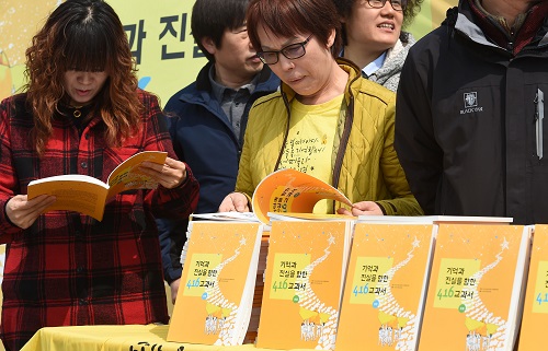 전국교직원노동조합 회원들과 416가족협의회가 22일 오후 경기도 안산시 세월호 참사 희생자 합동 분향소에서 열린 ‘기억과 진실을 향한 416 교과서’ 발간 및 세월호 희생자 합동분향소 헌정식에서 교과서를 살펴보고 있다. <사진제공=뉴시스>