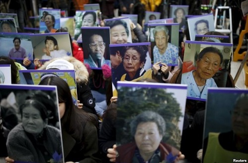 FILE – Students hold portraits of deceased former South Korean “comfort women” during a weekly anti-Japan rally in front of the Japanese Embassy in Seoul, South Korea, Dec. 30, 2015.2015년 12월 30일, 학생들이 한국 서울에 있는 일본대사관 앞에서 매주 열리는 반일집회에서 고인이 된 전 한국 ‘위안부’들의 사진을 들고 있다.