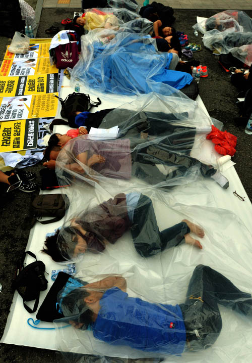 2014년 8월 23일 서울 종로구 청운효자동주민센터 앞에서 병원에 실려간 유민아빠 대책마련과 세월호 특별법 제정을 촉구하는 항의서한을 청와대에 전달한 단원고 학생 고 오영석 군의 아버지 오병환 씨 등 세월호 참사 가족대책위와 시민들이 청와대의 답변을 기다리며 간간히 내리는 비와 새벽이슬에 얇은 비닐 한 장만 덮고 밤샘 노숙을 하고 있는 모습. <사진제공=뉴시스>