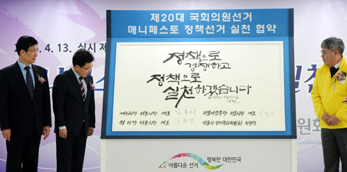 지난 3월14일 오후 서울 종로구 창경궁로 서울특별시선거관리위원회 5층 대회의실에서 열린 제20대 총선 매니페스토 정책선거 실천 협약식에서 정의당 김종민(오른쪽부터) 서울시당 위원장, 새누리당 김용태 서울시당 위원장, 더불어민주당 신경민 서울시당 위원장이 켈리그라피 이상현 작가가 쓴 문구에 서명하는 '정책선거 실천 다짐 퍼포먼스'를 하고 있다. <사진제공=뉴시스>