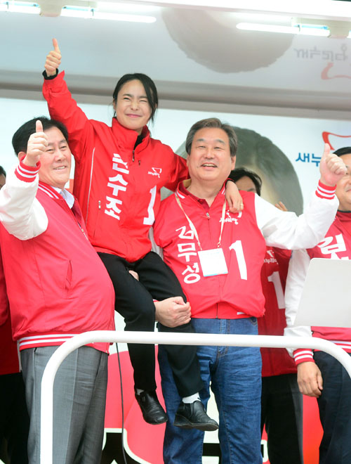 3일 오후 부산 사상구 이마트 사상점 앞에서 열린 손수조 후보의 유세현장을 찾은 김무성 새누리당 대표와 최경환 전 경제부총리가 손 후보를 안아서 올려보이고 있다. <사진제공=뉴시스>