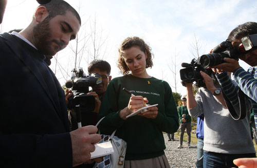 사회적 혁신기업 트리플래닛 관계자와 세월호 실종자·희생자 가족 등이 9일 오후 전남 진도군 임회면 백동리 무궁화동산에서 '세월호 기억의 숲' 완공식을 열고 있다. 오드리 헵번의 손녀 엠마 헵번(21·여)과 손자 아돈 헵번(20)이 희생자들에게 남기는 글을 적고 있다. <사진제공=뉴시스>