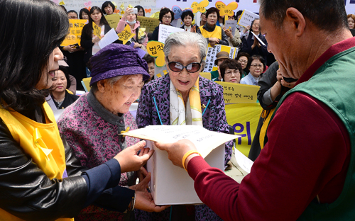 일본군 '위안부' 문제 해결을 위한 제1227차 정기 수요시위가 열린 20일 오후 서울 종로구 구 일본대사관 앞에서 길원옥(왼쪽 두번째), 김복동 할머니가 민주연합노동조합의 정의기억재단 기금 및 서명서를 전달받고 있다. <사진제공=뉴시스>