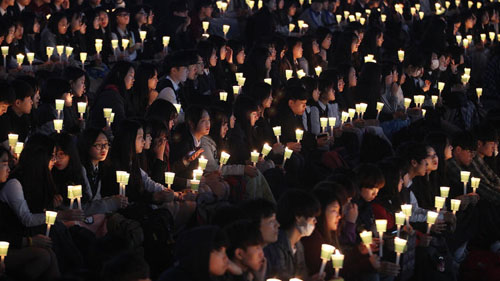 High school students hold candles to pay their respects to the victims of the Sewol ferry disaster during a ceremony April 15 on the eve of the sinking’s two-year anniversary in Ansan, South Korea. (Ahn Young-joon / Associated Press)세월호 침몰 2주기 전날인 4월15일 한국 안산에서 열린 추모제에서 고등학생들이 촛불을 들고 희생자들을 추모하고 있다.