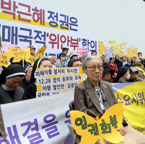 김복동 할머니를 비롯한 참석자들이 27일 오후 서울 종로구 중학동 구 일본대사관 앞에서 열린 1228차 일본군 '위안부' 문제해결을 위한 정기수요집회에 참석해 더불어민주당의 신경민, 홍익표 의원의 김종인 비대위 대표의 '한일 위안부 합의를 빨리 이행해야 한다'는 발언과 관련한 해명을 경청하고 있다. <사진제공=뉴시스>