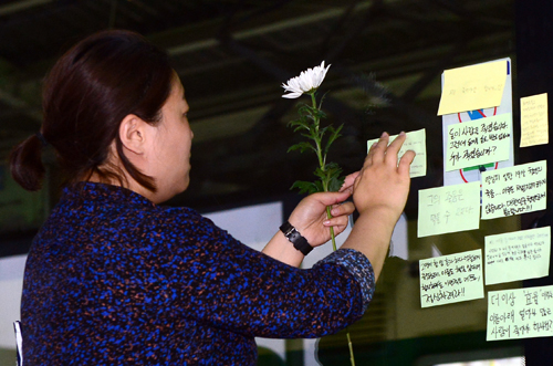 30일 오후 서울 광진구 구의역 9-4번 승강장을 찾은 시민이 스크린도어 정비 작업 중 사고로 숨진 김모(19)씨를 추모하는 메세지를 남기고 있다.김씨는 지난 28일 구의역의 고장난 스크린도어 정비 작업 중 승강장에 진입하던 열차와 스크린도어 사이에 끼여 숨졌다. <사진제공=뉴시스>