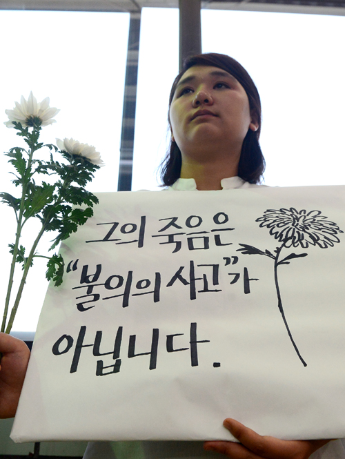 30일 오후 서울 광진구 구의역 9-4번 승강장을 찾은 시민이 스크린도어 정비 작업 중 사고로 숨진 김모(19)씨를 추모하는 피켓을 들고 있다.김씨는 지난 28일 구의역의 고장난 스크린도어 정비 작업 중 승강장에 진입하던 열차와 스크린도어 사이에 끼여 숨졌다. <사진제공=뉴시스>