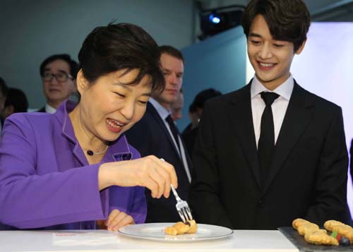 프랑스를 국빈 방문중인 박근혜 대통령이 2일 오후(현지시간) 파리 아르코 호텔 아레나에서 CJ가 개최하는 KCON 2016 France에 참석, 'K브랜드'를 알리기 위한 홍보부스에서 붕어빵을 맛보고 있다. 오른쪽은 샤이니의 민호.<사진제공=뉴시스>