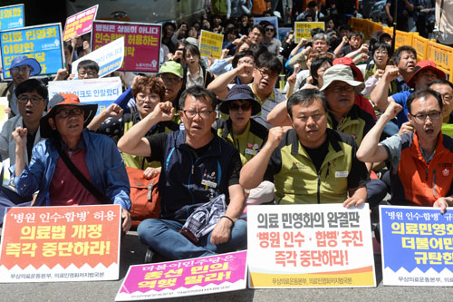 최동진(왼쪽 두 번째) 민주노총 수석 부위원장과 최권종(왼쪽 세 번째) 보건의료노조 수석부위원장 등 시민단체 회원들이 5월16일 오후 서울 여의도 더불어민주당 당사 앞에서 열린 의료민영화 저지결의대회에서 구호를 외치고 있다.<사진제공=뉴시스>