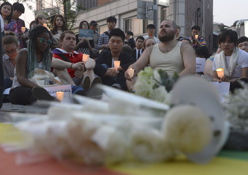 13일 저녁 서울 홍대입구역 인근에서 성소수자차별반대무지개행동 등 인권단체 주최로 열린 미국 올랜도 총기난사 사건 추모제에서 참가자들이 연대발언을 듣고 있다. <사진제공=뉴시스>