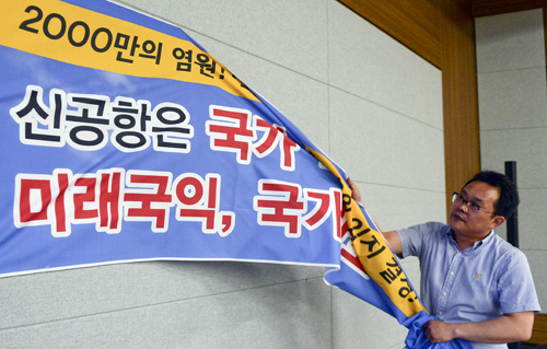 영남권 신공항 사전타당성 검토 용역결과 신공항 건설 계획이 백지화된 21일 오후 대구 동구 대구상공회의소에서 남부권신공항 범시도민 추진위원회 한 회원이 밀양 신공항 추진 플래카드를 철거하고 있다. 이날 브리핑에서 영남권 신공항 사전타당성 검토 용역을 맡은 프랑스 파리공항공단엔지니어링(ADPi)은 연구 결과를 발표하며 현재 김해공항을 확장하는 방안이 최적의 대안이라는 결론을 내렸다고 밝혔다. <사진제공=뉴시스>