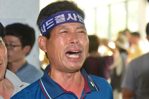 22일 오전 경북 성주군청 대강당에서 김항곤 군수가 기자회견을 하는 동안 김 군수의 기자회견 내용에 분노한 군민이 눈물을 흘리고 있다. <사진제공=뉴시스>