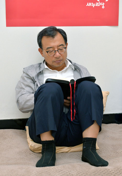 새누리당이 이정현 대표의 국정감사 복귀 권유를 정면 거부한 28일 저녁 서울 여의도 국회 새누리당 대표실에서 단식 3일째 밤을 맞고 있는 이정현 대표가 성경 시편을 읽고 있다. <사진제공=뉴시스>