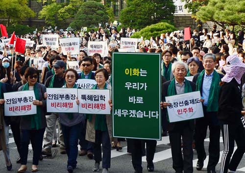 최경희 이대 총장이 사퇴의사를 밝힌 19일 오후 서울 서대문구 이화여자대학교 본관 앞에서 교수와 학생들이 최 총장 사퇴에 환호하며 행진을 하고 있다.<사진제공=뉴시스>