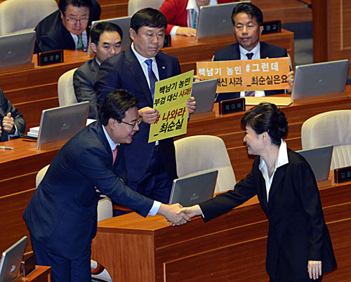 24일 서울 여의도 국회 본회의장에서 박근혜 대통령이 시정연설을 마치고 단상에서 내려오고 있다. 박대통령 뒷편으로 울산출신 무소속 김종훈, 윤종오 의원이 '나와라 최순실'이라고 적힌 손팻말을 들고 있다. <사진제공=뉴시스>