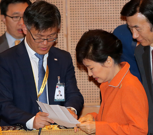 박근혜 대통령이 2015년 11월21일 오후 말레이시아 쿠알라룸푸르 컨벤션센터 컨퍼런스홀에서 열린 ASEAN+3와 동아시아 기업인 협의회간 대화에 참석해 정호성 부속비서관과 이야기를 나누고 있다. <사진제공=뉴시스>