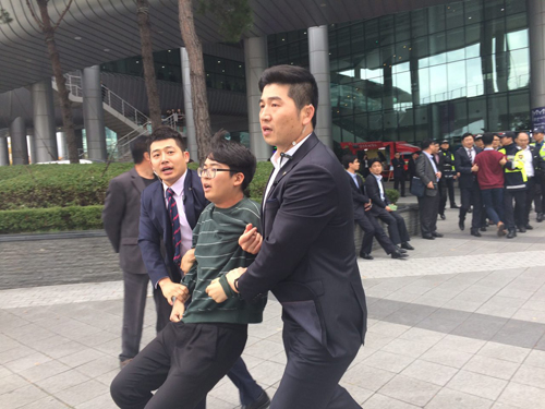 박근혜 대통령이 27일 부산 벡스코 2전시관에서 열리는 4회 지방자치의날 기념식에 축사를 하기 위해 참석한 가운데 대학생들이 '박근혜 대통령 하야 촉구 기습시위' 를 펼치고 있다. <사진=독자 제공, 뉴시스>