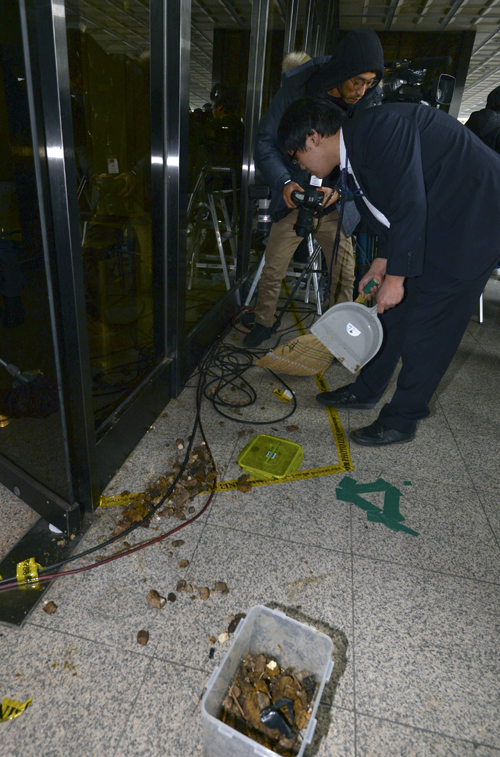 '비선실세' 국정농단 사태와 관련해 최순실 씨가 검찰에 출두한 31일 오후 서울 서초구 서울중앙지검에서 한 시민이 유리창에 던진 개똥을 검찰 관계자가 치우고 있다. <사진제공=뉴시스>