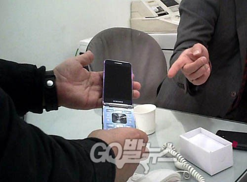 최순실-박근혜 두 사람이 사용했다는 대포폰과 같은 기종의 삼성 갤럭시 폴더폰을 핸드폰 대리점 업주가 고발뉴스 취재팀에 보여주고 있다. ⓒ go발뉴스