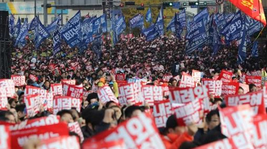South Korean protesters hold up signs that read ‘Step down Park Geun-hye’ (PIcture: AP Photo/Lee Jin-man)한국 시위자들이 ‘내려와 박근혜’라고 적힌 사인을 들고 있다.