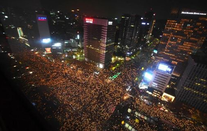 Protesters hold candles during an anti-government rally (Picture: AFP/Getty Images)시위자들이 반정부 시위 중 촛불을 들고 있다.