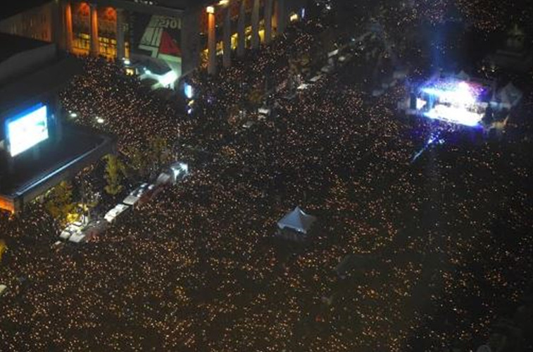 Protesters hold candles during an anti-government rally (Picture: AFP/Getty Images)시위자들이 반정부 시위 중 촛불을 들고 있다.