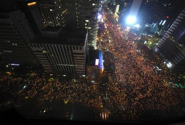 Protesters hold candles during an anti-government rally (Picture: AFP/Getty Images)시위자들이 반정부 시위 중 촛불을 들고 있다.