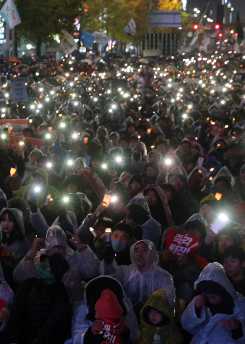 26일 오후 서울 중구 태평로 서울광장에서 열린 박근혜 대통령 퇴진 제5차 범국민행동 촛불집회에 참여한 시민들이 촛불을 들고 있다. <사진제공=뉴시스>