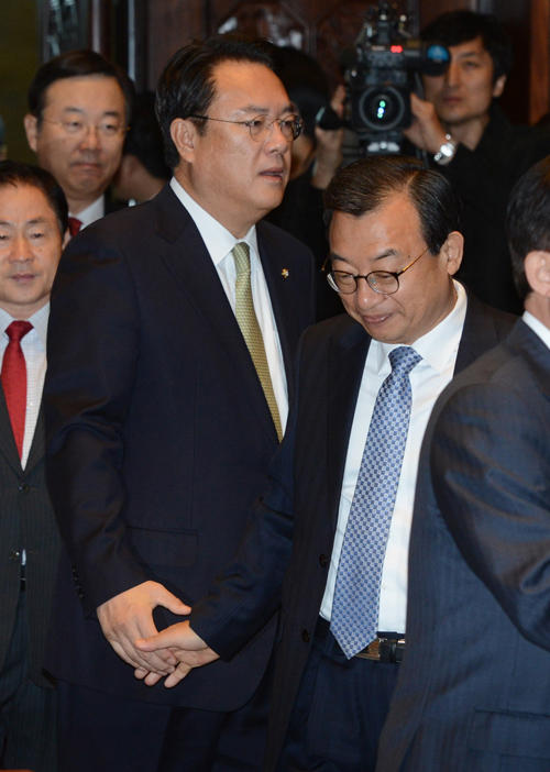 이정현 새누리당 대표가 1일 오전 서울 여의도 국회 예결위회의장에서 열린 의원총회에서 정진석 원내대표와 악수를 나눈 뒤 돌아서고 있다. 새누리당이 박근혜 대통령의 내년 4월 퇴진, 6월 대선 로드맵을 당론으로 채택했다. <사진제공=뉴시스>