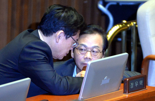 새누리당 정우택 원내대표가 20일 오후 서울 여의도 국회에서 열린 경제분야 대정부질문에 참석해 청문회 증인 위증 교사 의혹을 받고 있는 이완영 의원과 대화하고 있다. <사진제공=뉴시스>