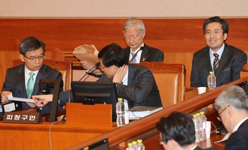 10일 오전 서울 종로구 헌법재판소 대심판정에서 열린 박근혜 대통령 탄핵심판 3차 공개 변론에서 박 대통령 측 법률대리인단 단장인 이중환 변호사가 관계자와 논의하고 있다. <사진제공=뉴시스>