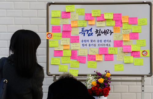 19일 서울 강남구 대치동 특검 건물 앞에서 시민들이 특검 응원 메시지를 붙이고 있다. <사진제공=뉴시스>