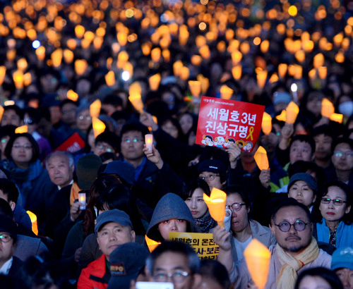 ▲ 15일 서울 종로구 광화문 광장에서 열린 ‘세월호 3주기 22차 범국민행동의 날’에서 시민들이 촛불을 들고 있다. <사진제공=뉴시스>